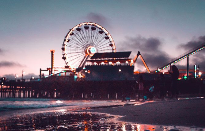 A ferris wheel on the beach at night.