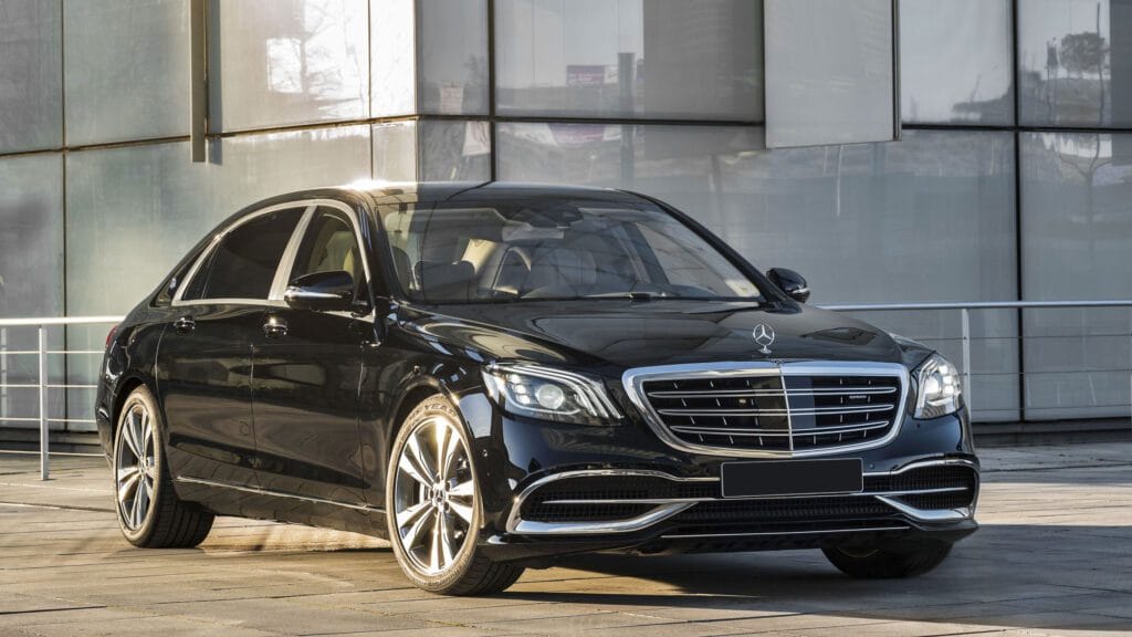 A black mercedes benz parked in front of a building.