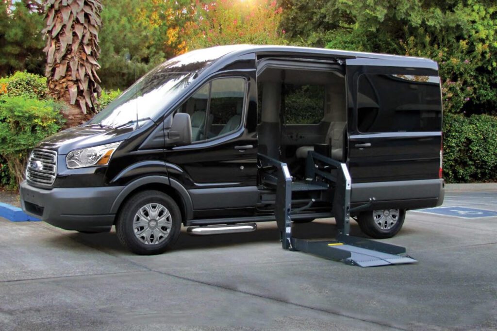 A van with the door open and a ramp in front of it.