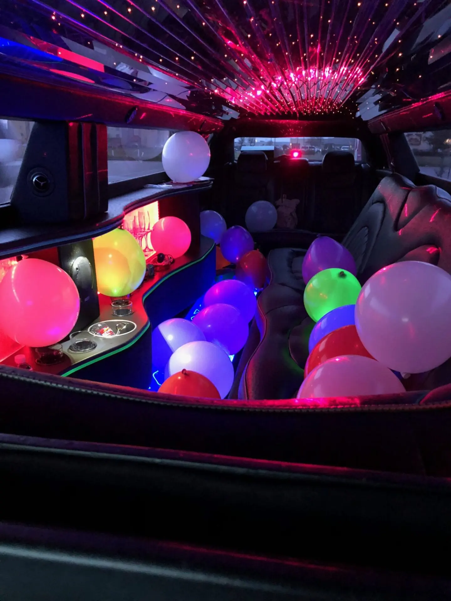 A bunch of balloons in the back of a limo