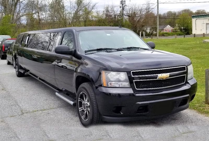 A black limo is parked on the side of the road.