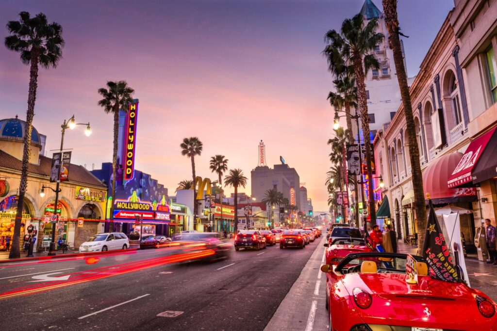 A street with palm trees and cars on the side.