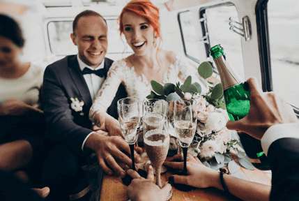 A man and woman sitting at a table with champagne.