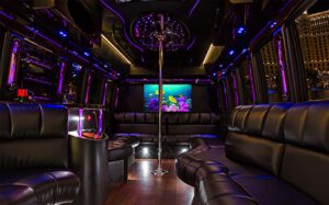 A room with purple lighting and black leather furniture.