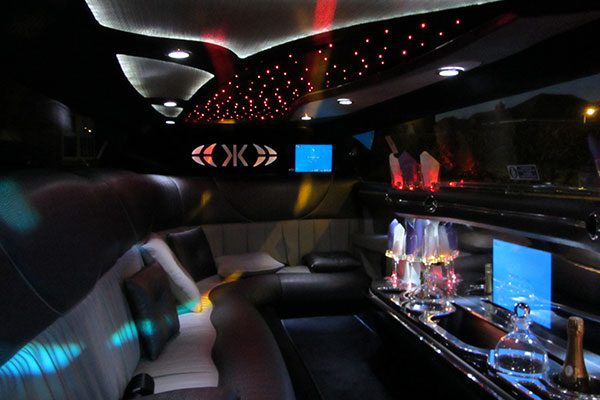 A limo with lights on the ceiling and seats.