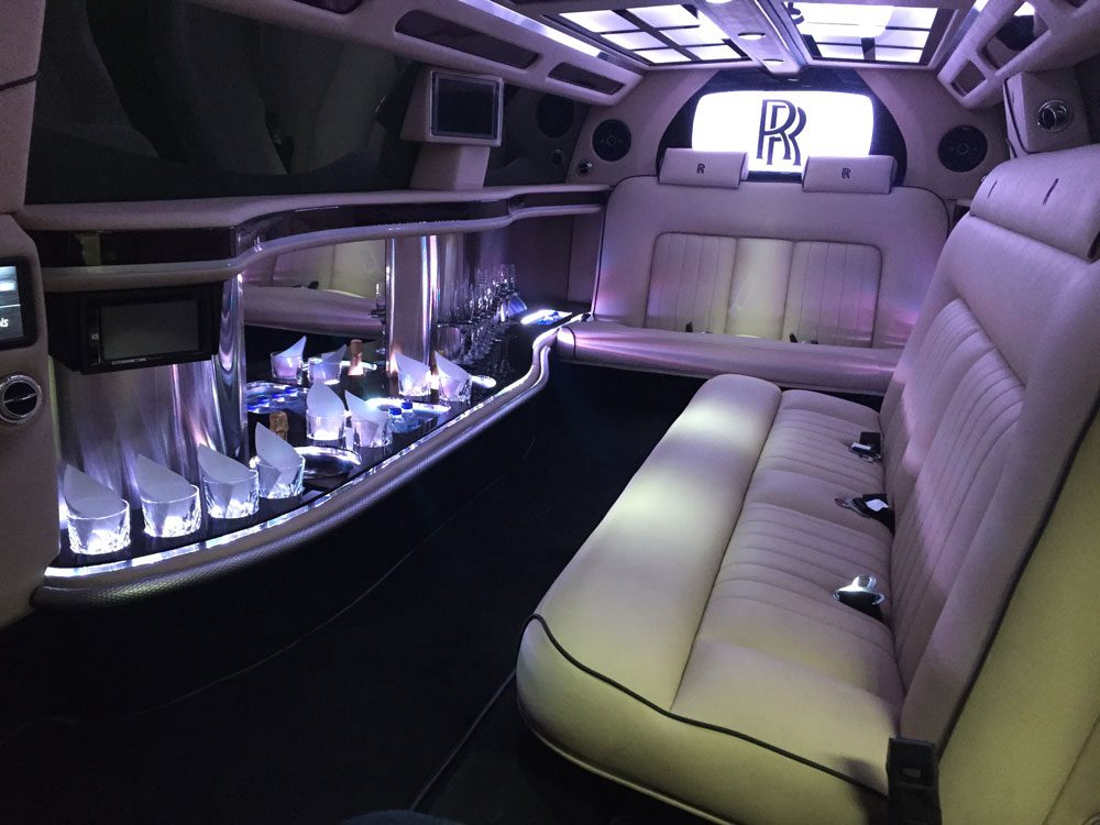 A limo car with seats and tables in it