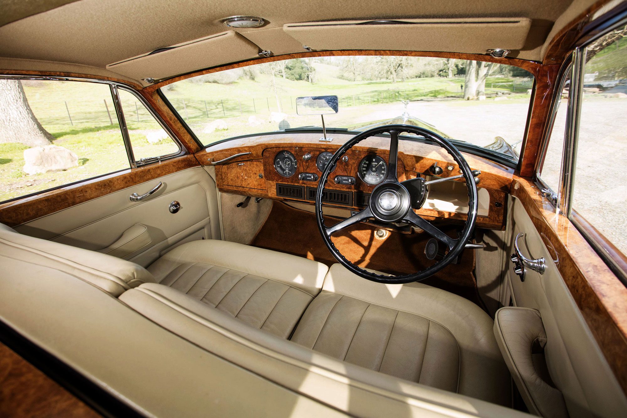 A car with beige leather seats and steering wheel.