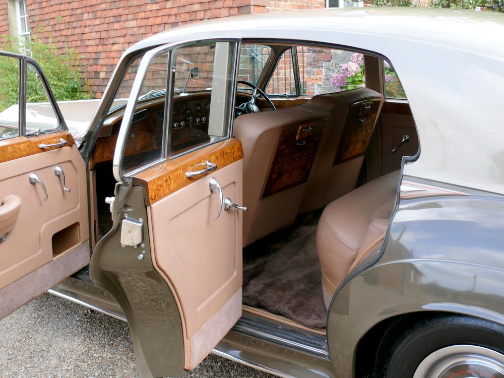 A car with the door open and the rear seats folded down.