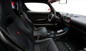 A car with black leather seats and red trim.