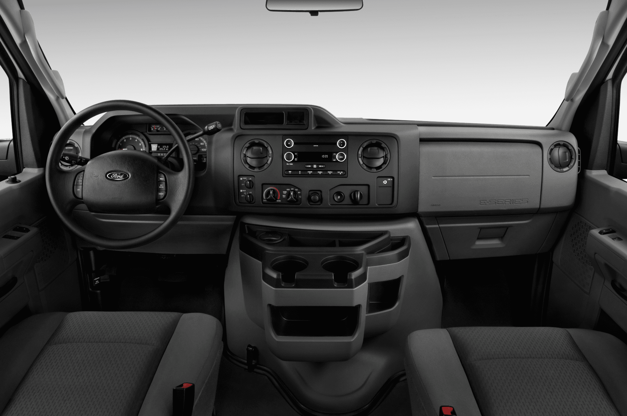 A dashboard of an automobile with the steering wheel and center console.