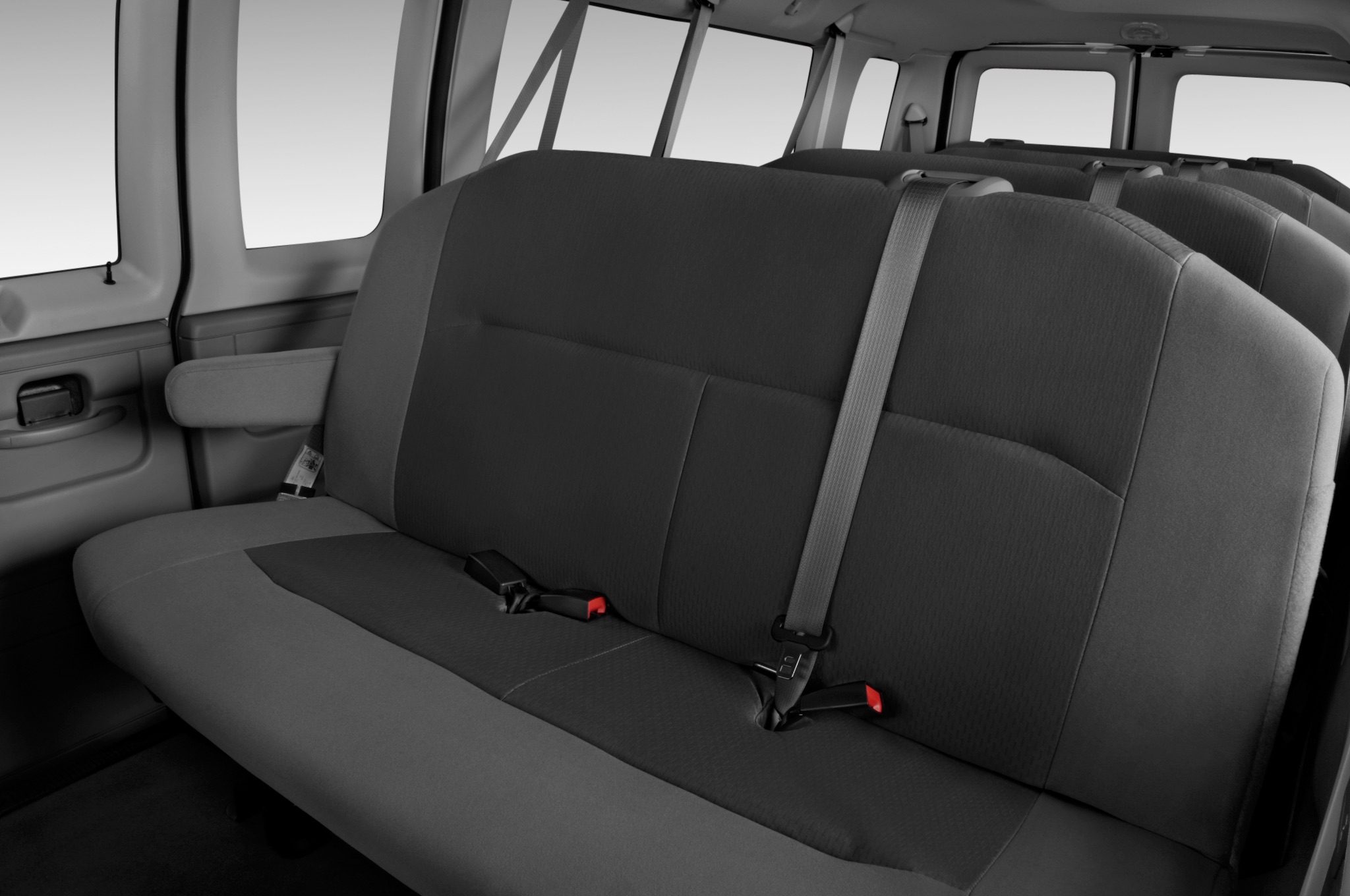 A black and white photo of the back seats in a van.