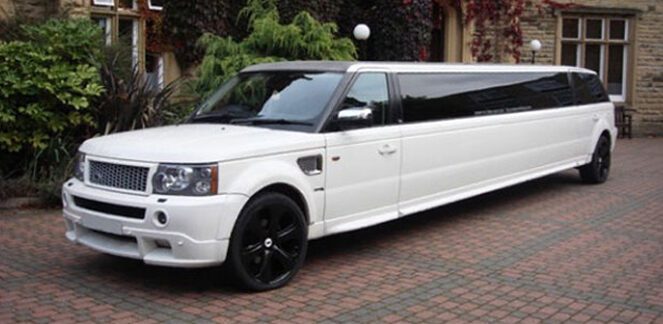 A white limo is parked on the brick driveway.