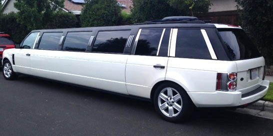 A white limo is parked in the street.