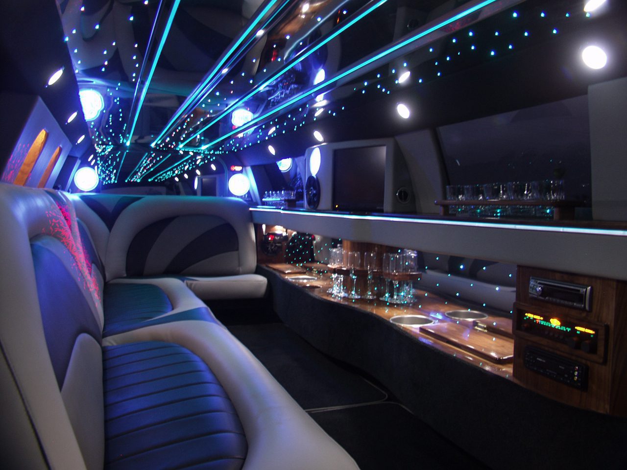 A limo with lights on the ceiling and tables in front of it.