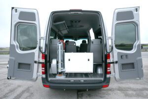 A van with the back door open and the rear seats folded down.