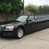 A black limo parked in the driveway of a house.