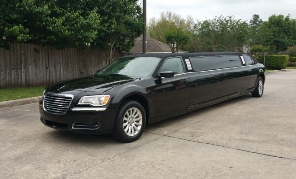 A black limo parked in the driveway of a house.