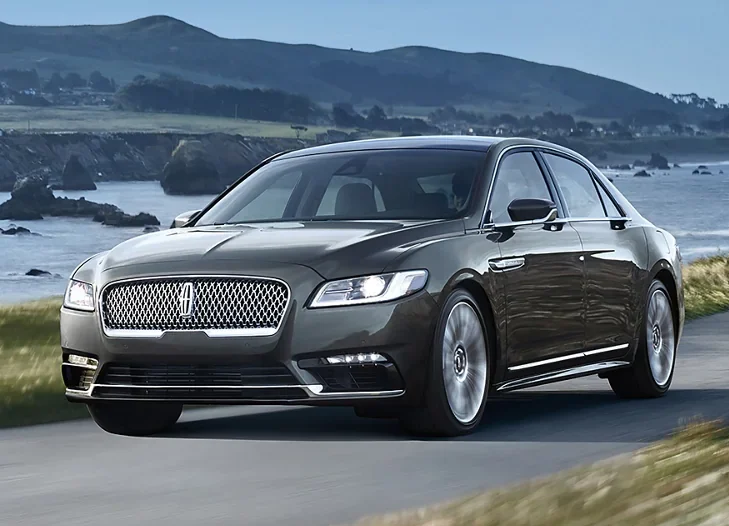 A black lincoln continental driving down the road.