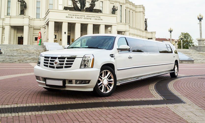 A white limo is parked on the side of the street.