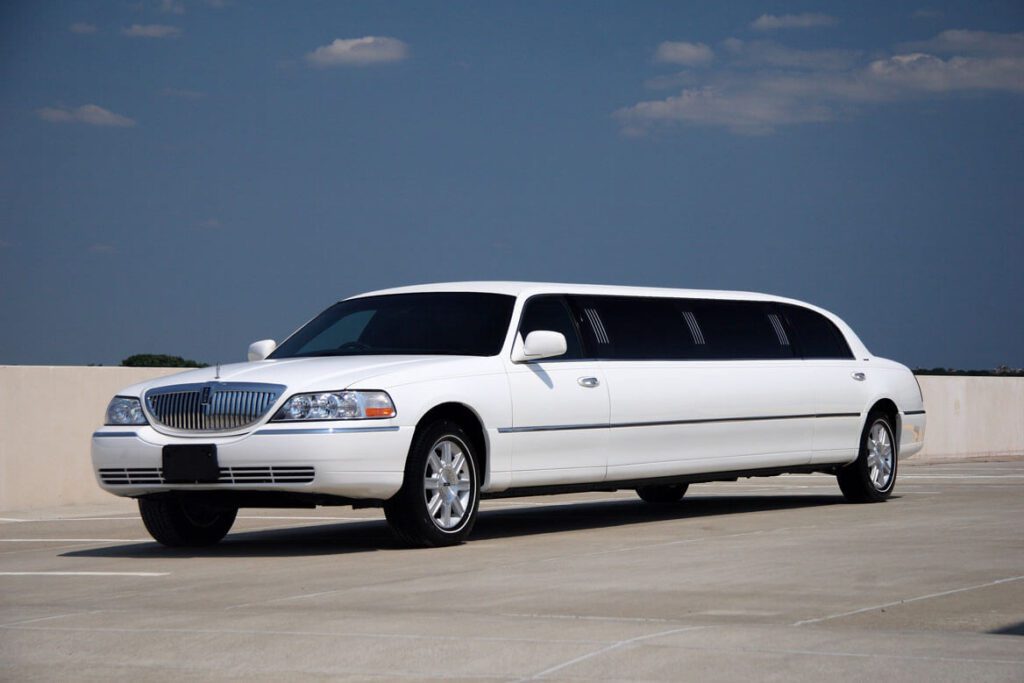 A white limo is parked on the street.