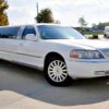 A white limo is parked in the parking lot.