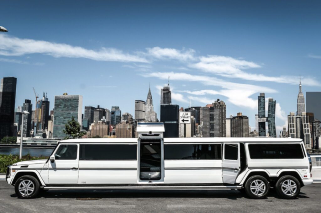 A white limo parked in front of the city skyline.