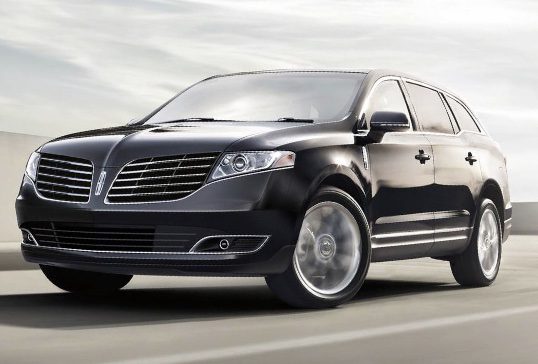 A black lincoln mkt is driving down the street.