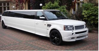 A white limo is parked on the side of the road.