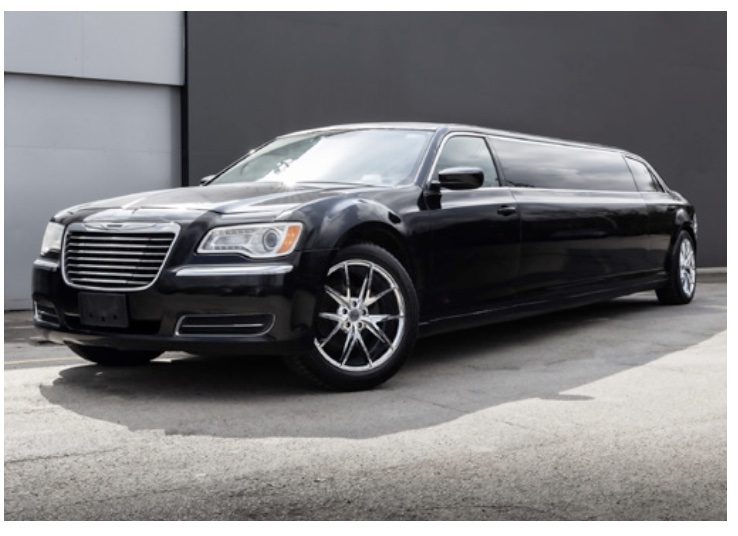 A black limo parked in front of a building.