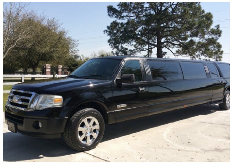 A black limo is parked in the driveway.