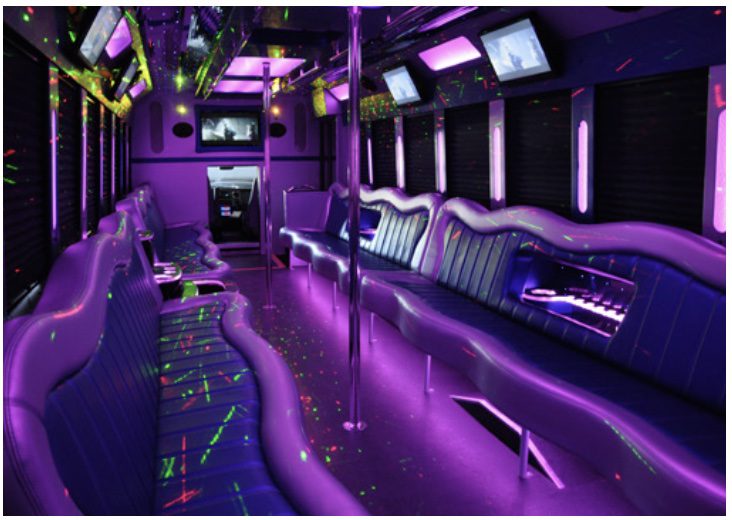 A purple party bus with neon lights and musical instruments.