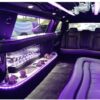 A purple limo with the lights on.