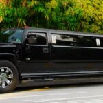 A black limo driving down the street