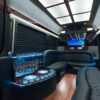 A party bus with black leather seats and blue lighting.