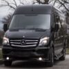 A black mercedes benz van is parked on the street.