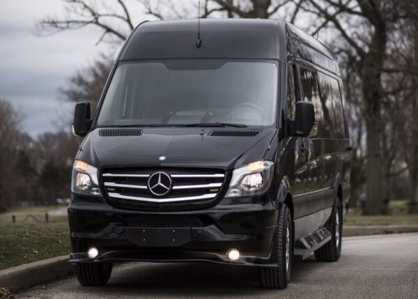 A black mercedes benz van is parked on the street.