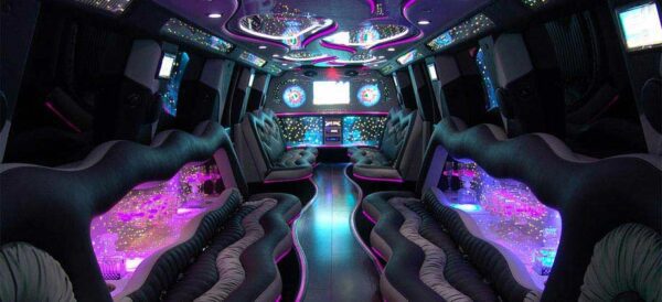 A party bus with purple lights and black leather seats.