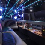 A limo with lights on the ceiling and tables in front of it.