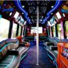 A party bus with blue lights and black leather seats.