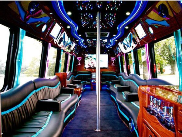 A party bus with blue lights and black leather seats.