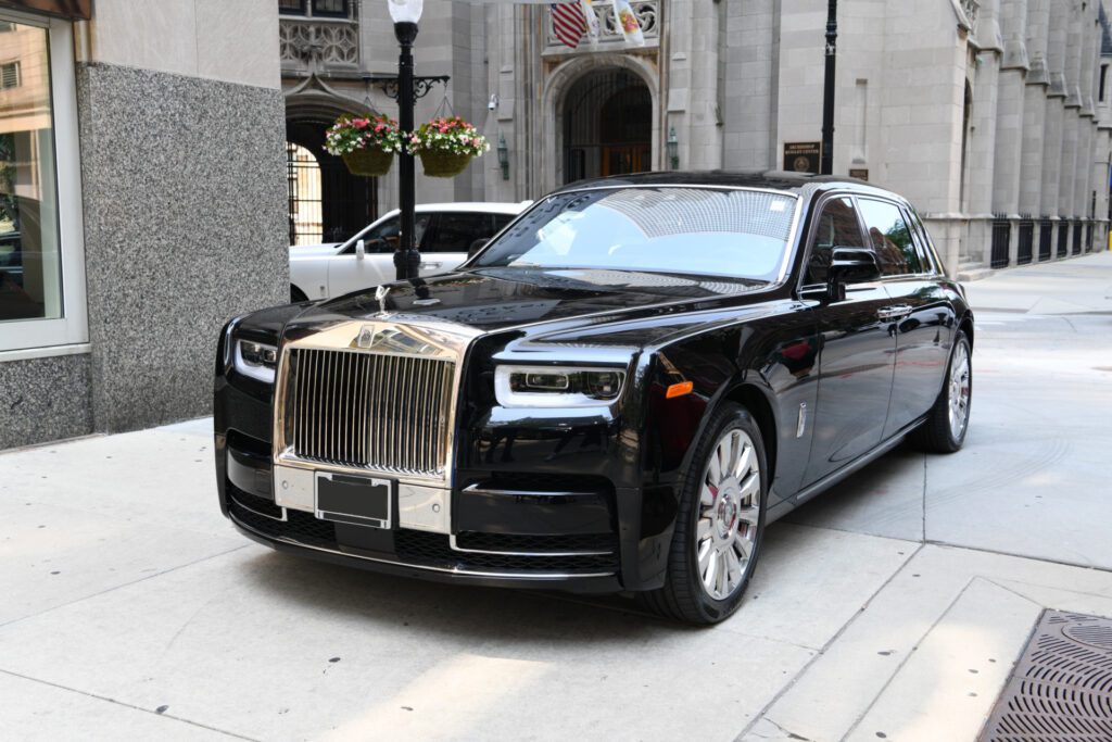 A black rolls royce parked on the side of a street.