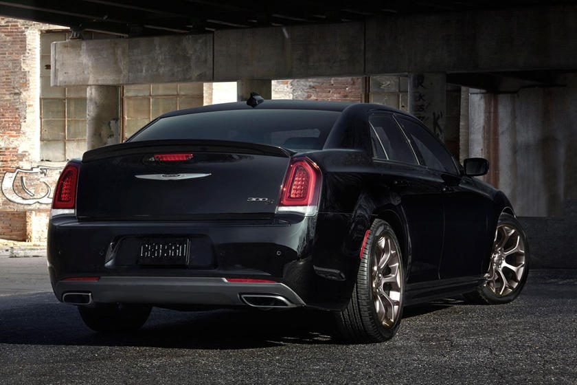 A black car parked in the middle of a parking lot.