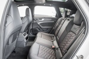 A car with the seats folded down in a back seat.