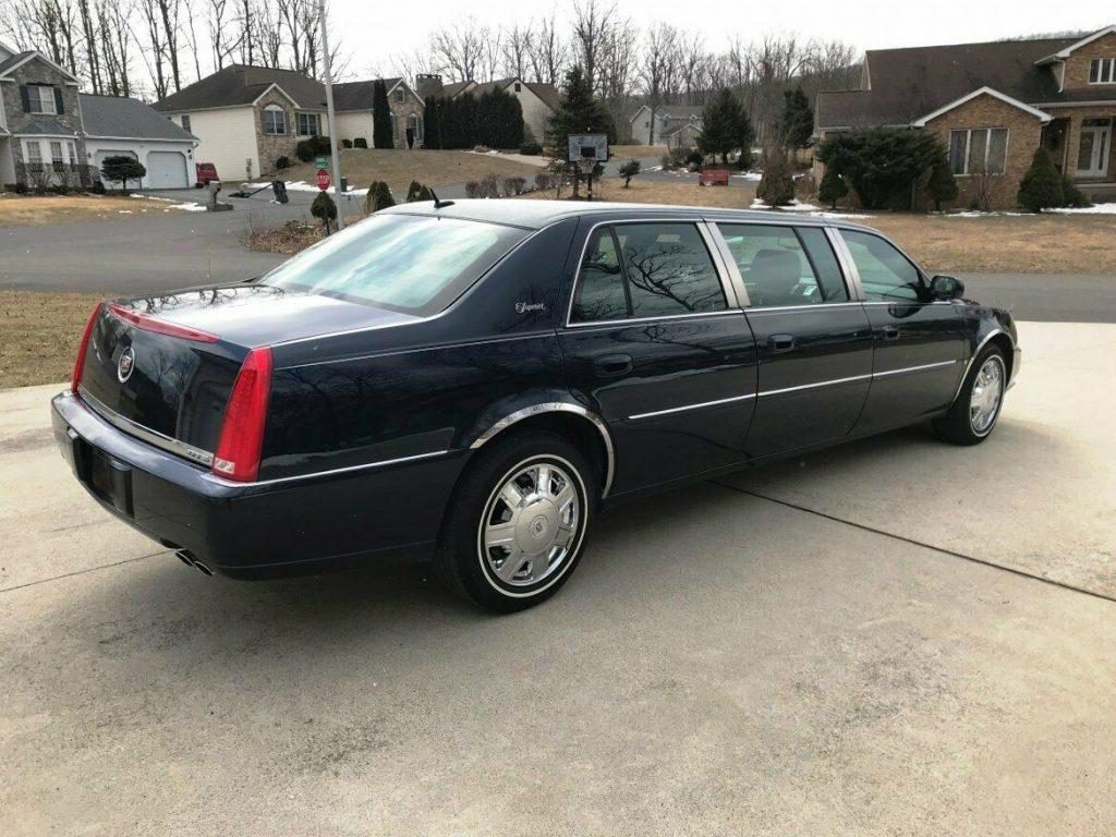 A black limo is parked in the driveway.