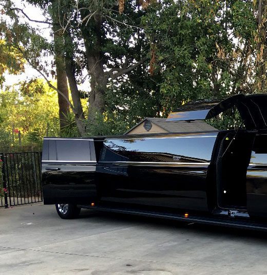 A black limo parked in the driveway of a house.