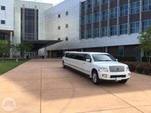 A white limo parked in front of a building.