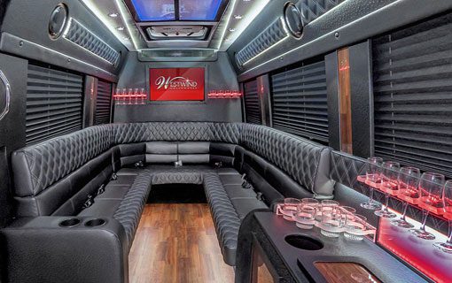 A room with black leather couches and tables.