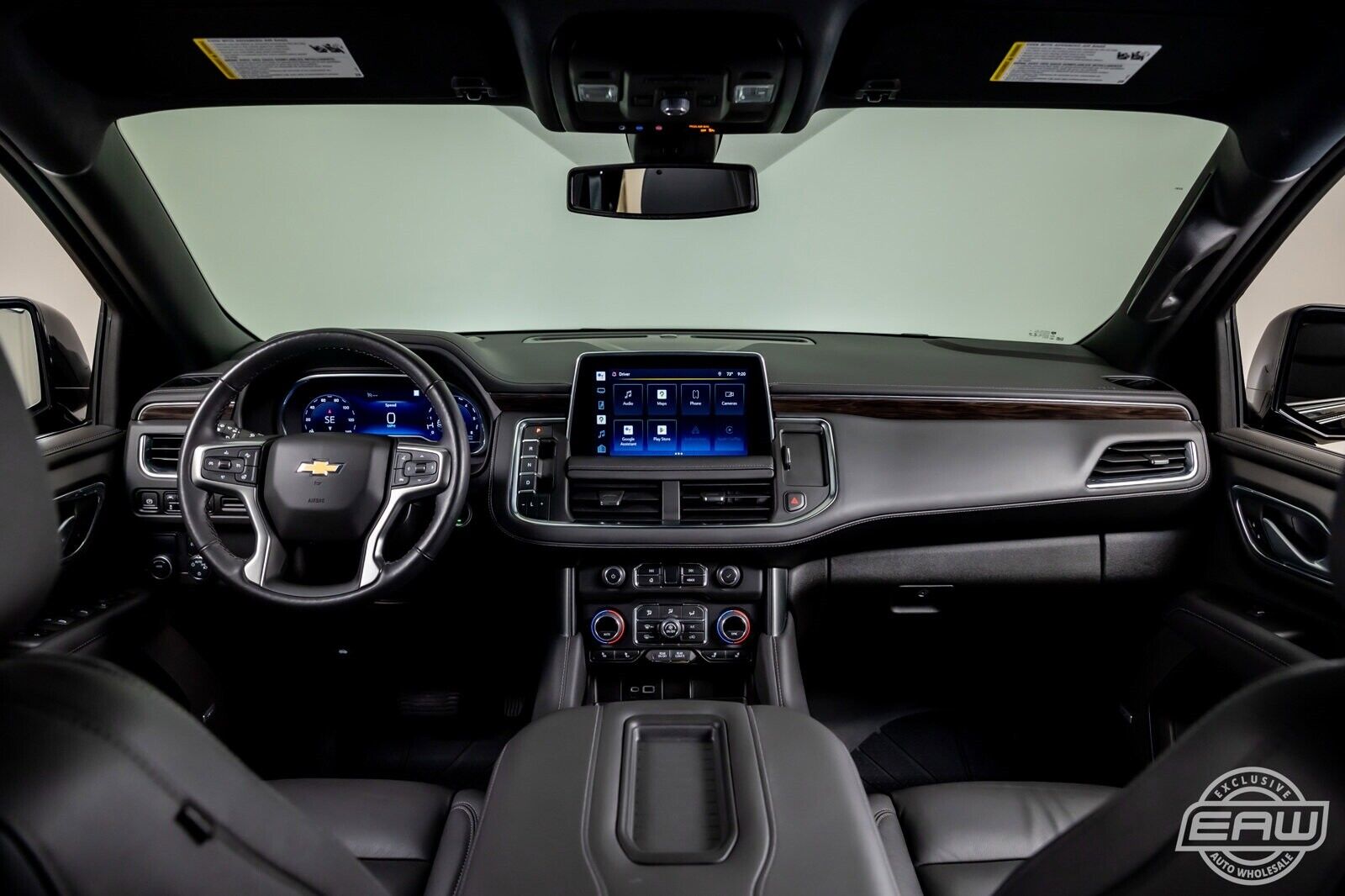 A dashboard of a car with the steering wheel and infotainment system.