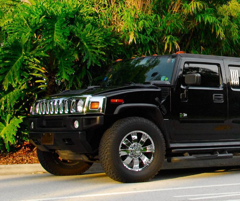 A black hummer driving down the street.