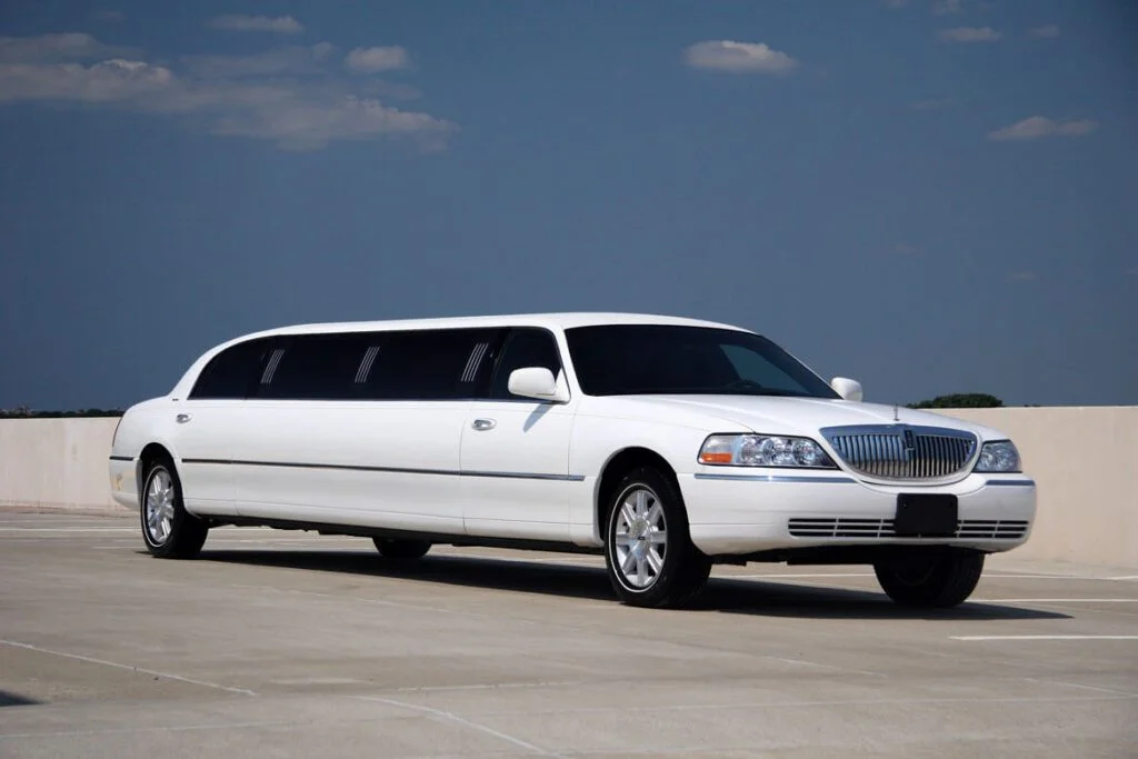 A white limo is parked on the street.